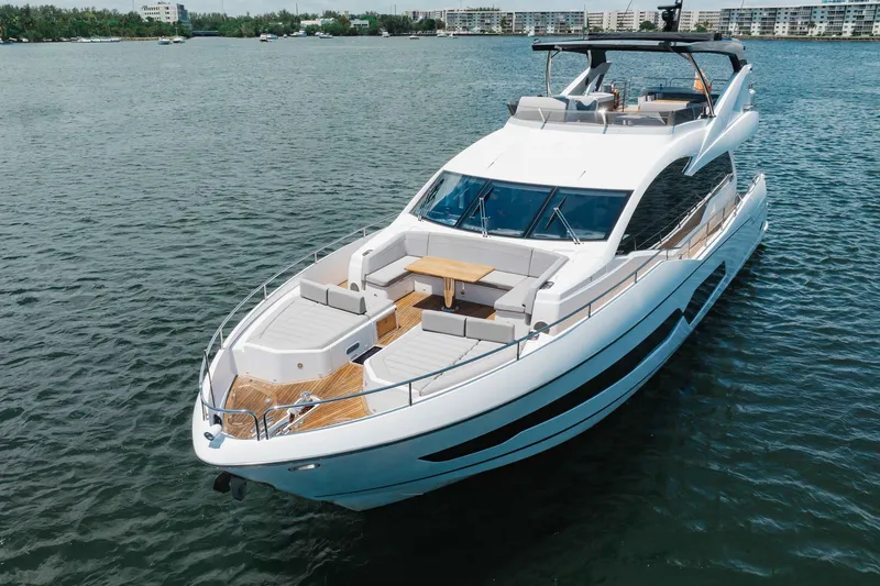 Slide: The Image of 2022 Sunseeker 76 Yacht cruising on calm waters, showcasing luxury design and spacious deck. - 9