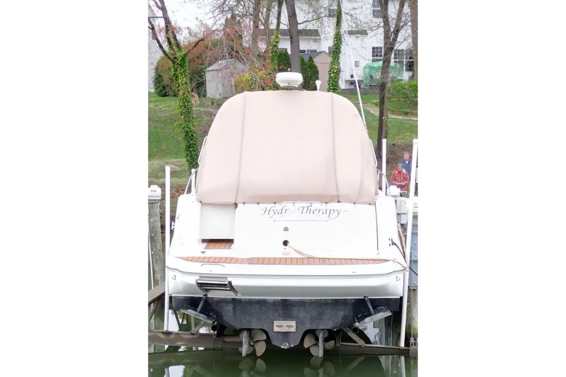 Slide: The Image of 2004 Sea Ray 340 Sundancer yacht docked with beige cover, rear view. - 10
