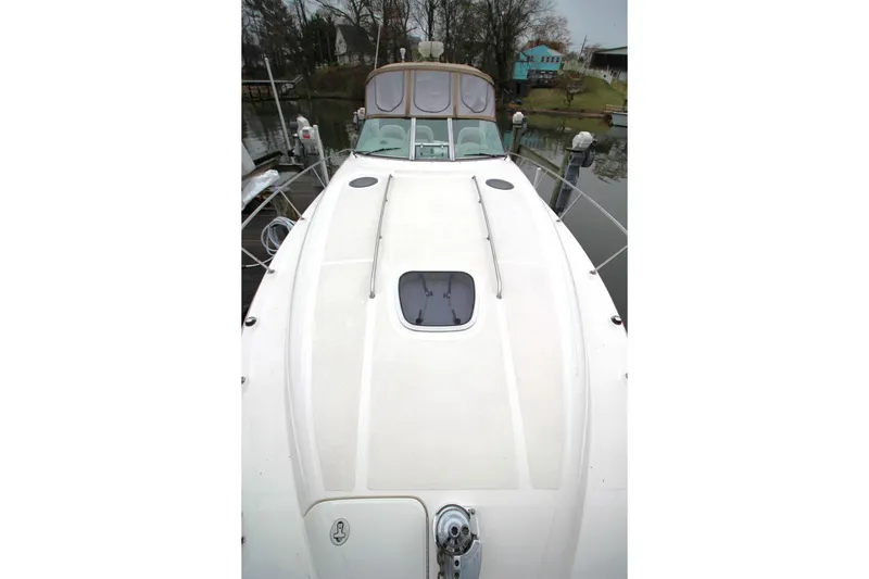 Slide: The Image of 2004 Sea Ray 340 Sundancer yacht docked, showcasing sleek deck design and spacious layout. - 13