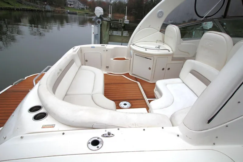 Slide: The Image of Luxurious 2004 Sea Ray 340 Sundancer boat interior with white seating and wooden deck. - 14