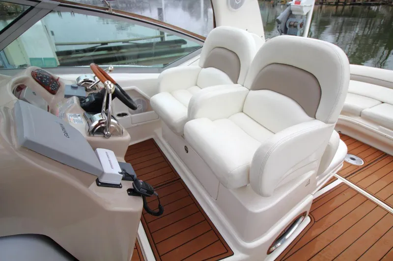 Slide: The Image of 2004 Sea Ray 340 Sundancer cockpit with white leather seats and wooden flooring. - 15
