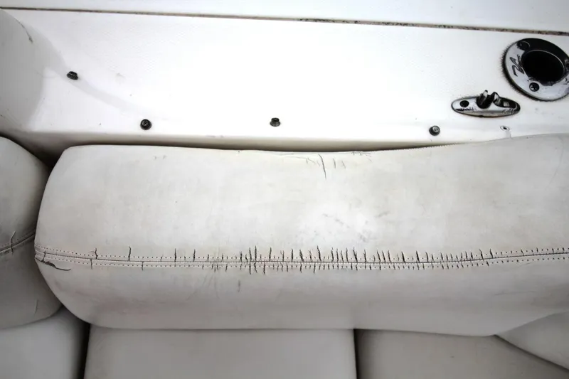 Slide: The Image of Worn upholstery on a 2004 Sea Ray 340 Sundancer boat seat, showing visible stitching damage. - 18
