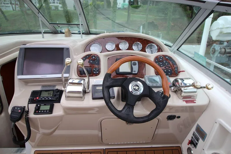 Slide: The Image of 2004 Sea Ray 340 Sundancer helm with steering wheel, gauges, and navigation equipment. - 19