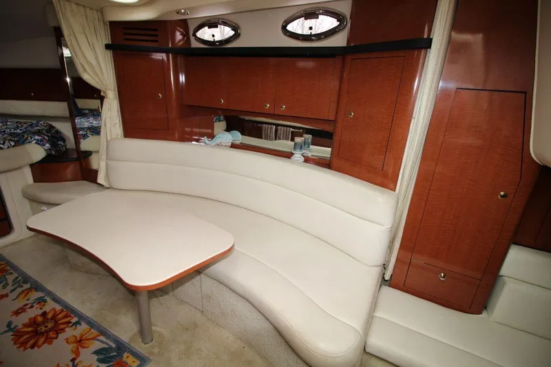 Slide: The Image of Interior of 2004 Sea Ray 340 Sundancer yacht with curved seating and wooden cabinetry. - 21