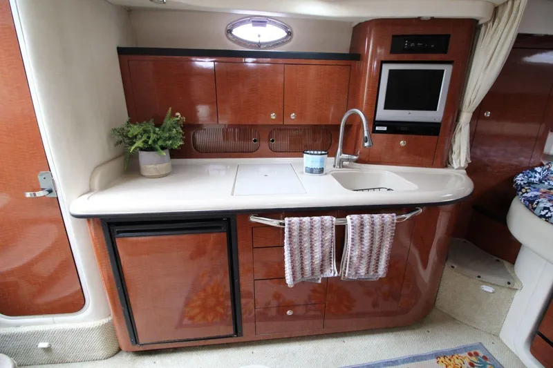Slide: The Image of 2004 Sea Ray 340 Sundancer interior with kitchenette, sink, and TV. - 22