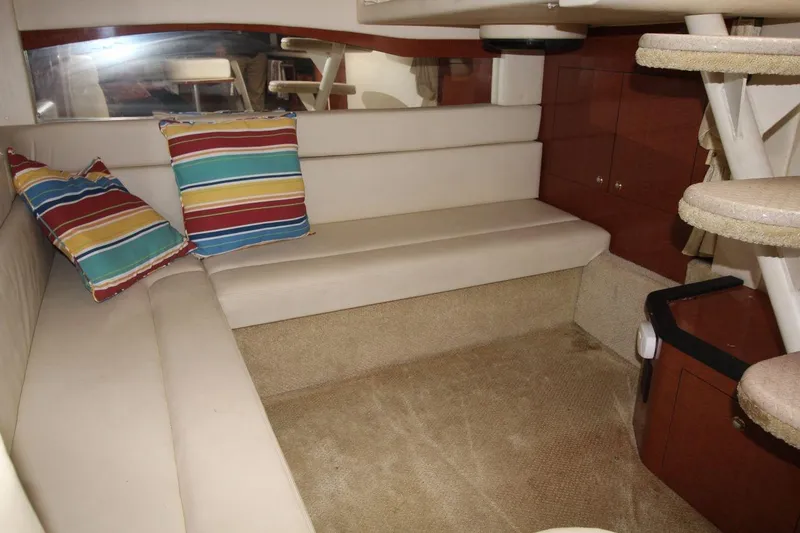 Slide: The Image of Interior of 2004 Sea Ray 340 Sundancer with beige seating and colorful pillows. - 24