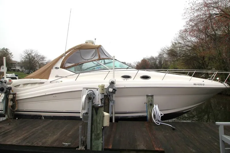 Slide: The Image of 2004 Sea Ray 340 Sundancer docked, featuring sleek design and beige canopy. - 5