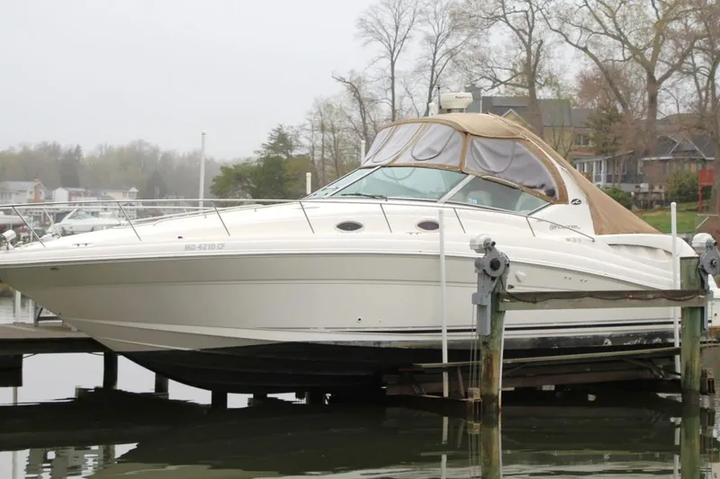 Slide: The Image of 2004 Sea Ray 340 Sundancer boat docked at a marina, featuring a sleek design. - 6