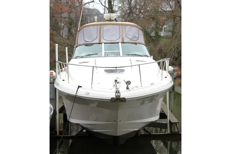 Slide: The Image of 2004 Sea Ray 340 Sundancer boat docked, front view with trees in the background. - 7