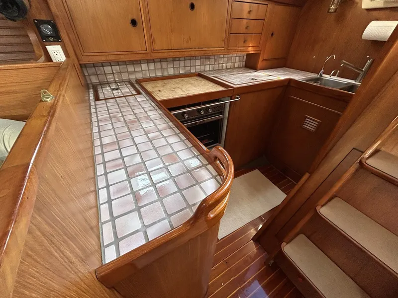 Slide: The Image of 1987 Wauquiez Centurion interior with wooden kitchen and tiled countertop. - 12