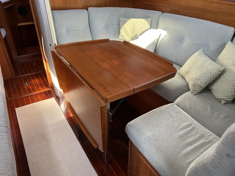 Slide: The Image of Interior of a 1987 Wauquiez Centurion yacht with wooden table and cushioned seating. - 16