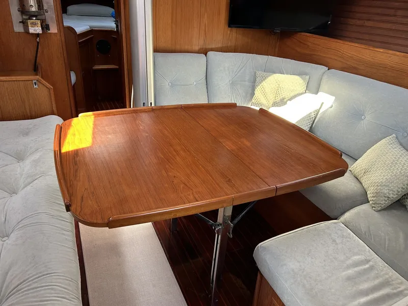 Slide: The Image of Interior of a 1987 Wauquiez Centurion yacht with wooden table and cushioned seating. - 20