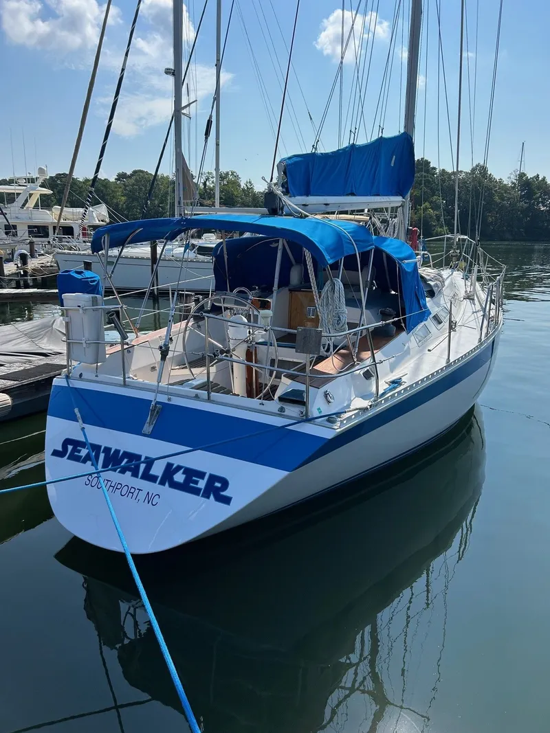 Slide: The Image of 1987 Wauquiez Centurion sailboat docked, blue canopy, named "Seawalker". - 3