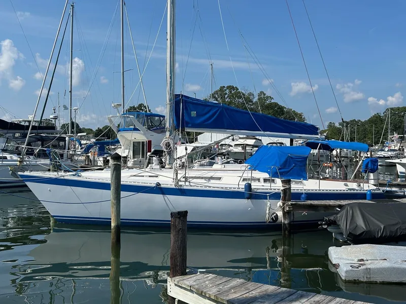 Slide: The Image of 1987 Wauquiez Centurion sailboat docked, featuring blue and white covers. - 4