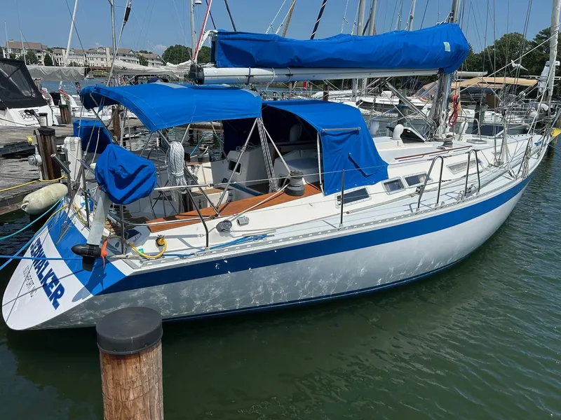 Slide: The Image of 1987 Wauquiez Centurion sailboat docked with blue covers. - 5