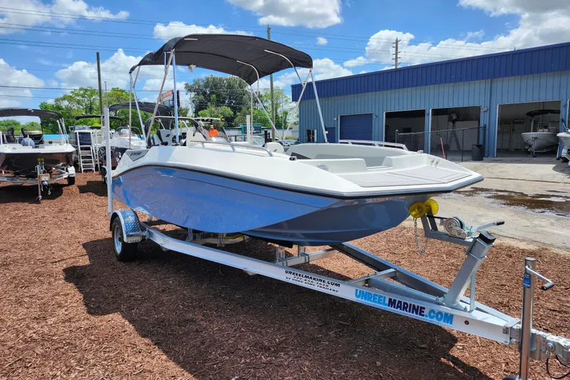 The Image of 2026 Starcraft SV 18 OB boat on trailer at a marina under blue sky. - 1