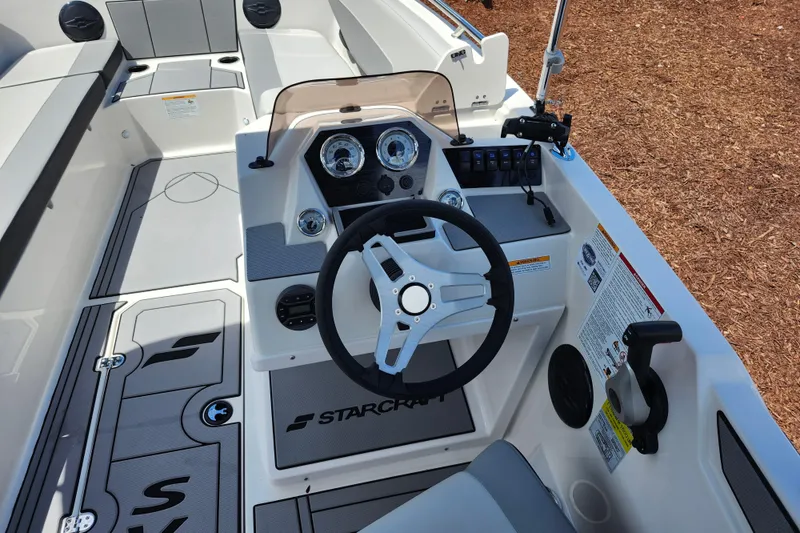 Slide: The Image of Interior view of 2026 Starcraft SV 18 OB boat cockpit with steering wheel and controls. - 12