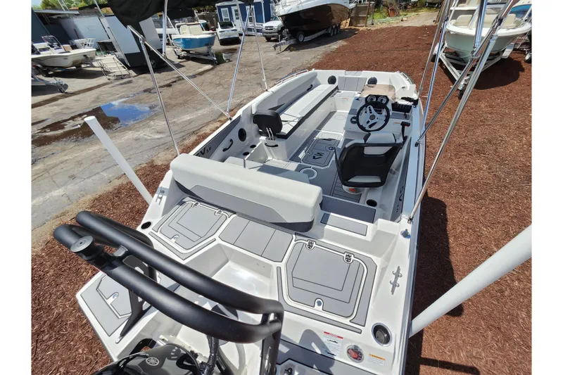 Slide: The Image of 2026 Starcraft SV 18 OB boat interior with steering wheel and seating, displayed outdoors. - 21