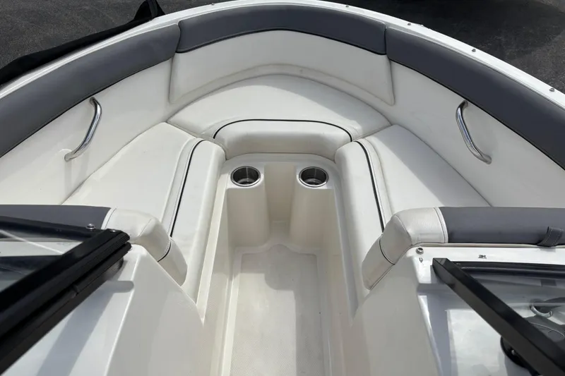 Slide: The Image of 2018 Bayliner 180 Bowrider interior with white seating and cup holders. - 10