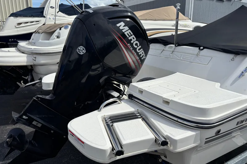 Slide: The Image of 2018 Bayliner 180 Bowrider with Mercury outboard engine, docked alongside other boats. - 3