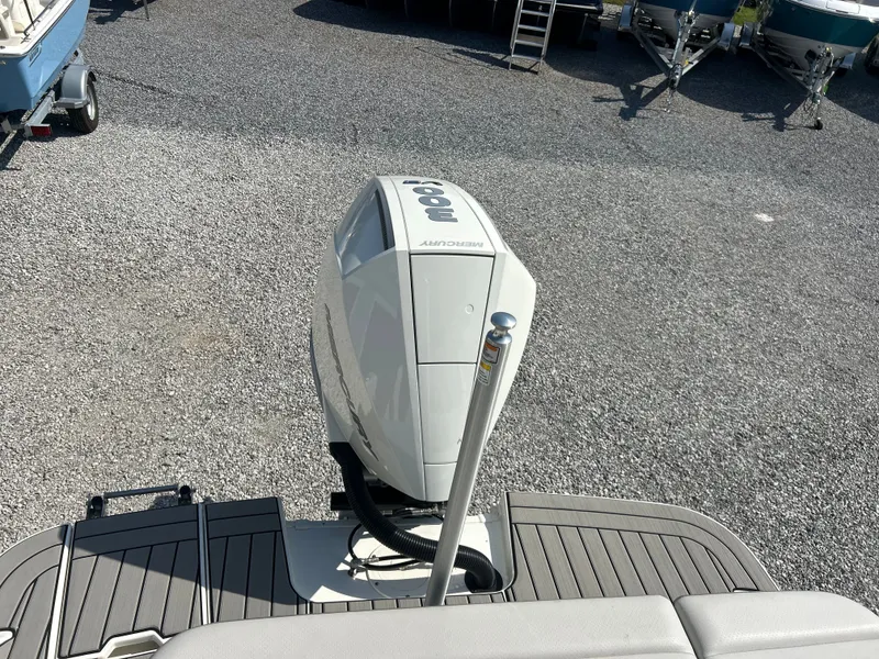 Slide: The Image of Outboard motor on a boat, surrounded by gravel and other boats. - 21