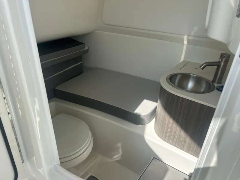 Slide: The Image of The image shows a compact boat cabin with a toilet, sink, and seating area. - 13