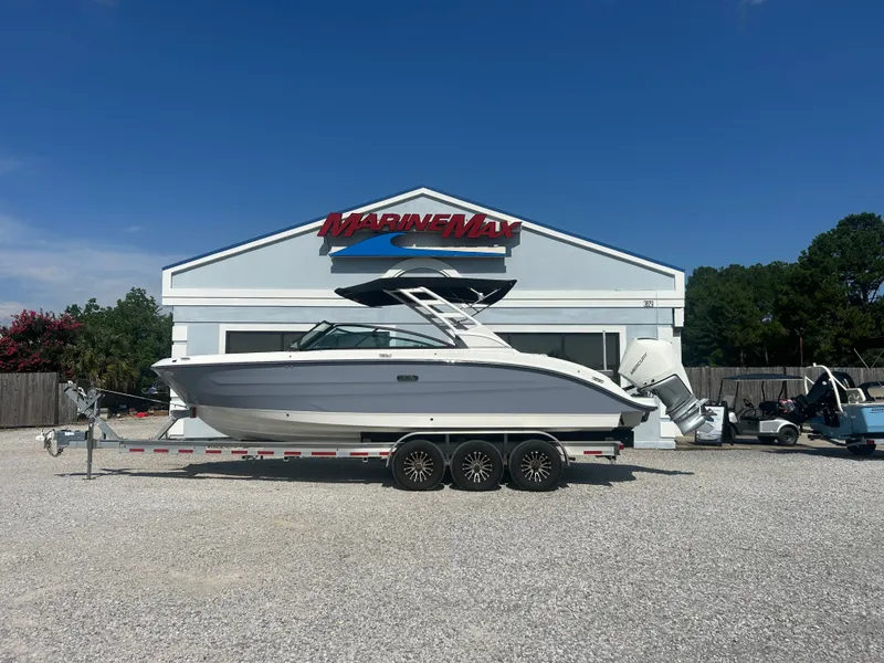 Slide: The Image of A 2027 Sea Ray 270SD-OB boat on a trailer in front of a MarineMax building. - 0