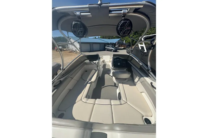 Slide: The Image of 2012 Yamaha AR210 boat interior with seating and speakers, parked outdoors. - 11
