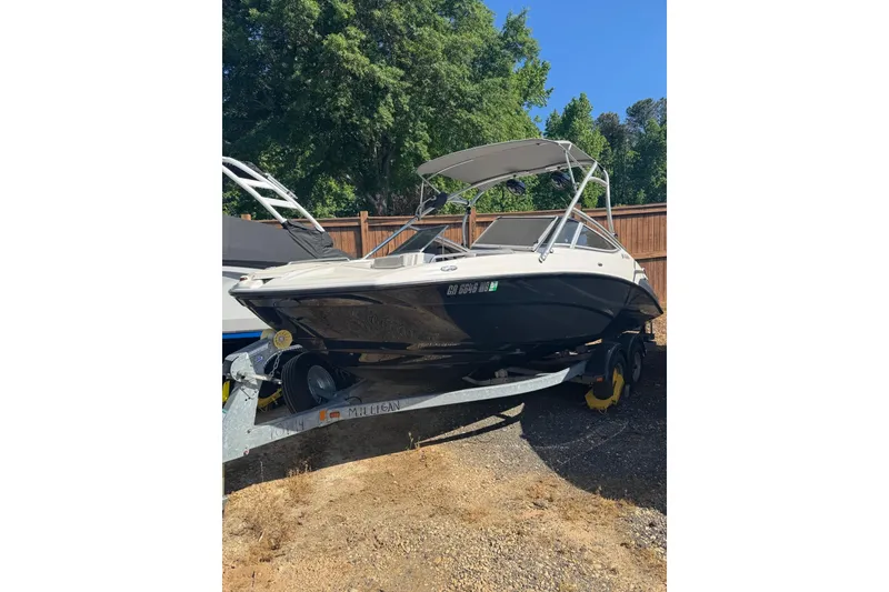 Slide: The Image of 2012 Yamaha AR210 boat on trailer, parked outdoors near wooden fence. - 7