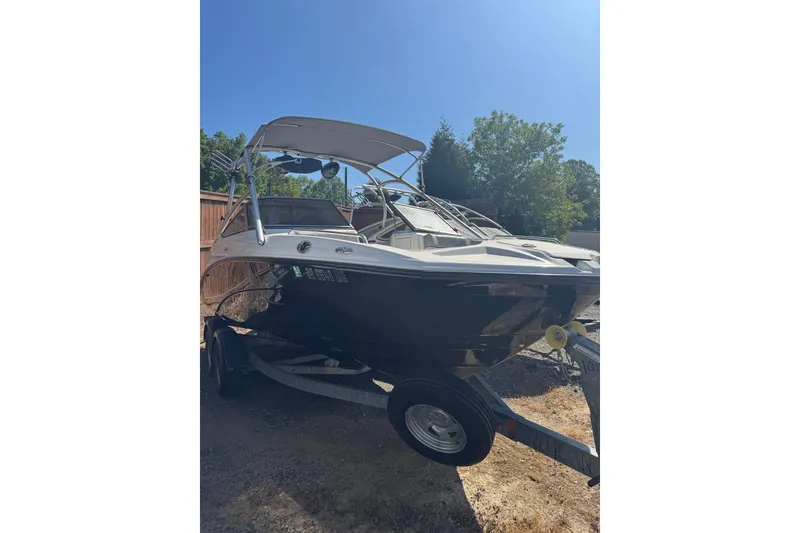 Slide: The Image of 2012 Yamaha Boats AR210 on trailer, parked outdoors under clear blue sky. - 8