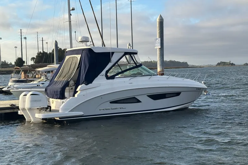 The Image of 2020 Regal 33 XO boat docked in a marina with Yamaha engines. - 0