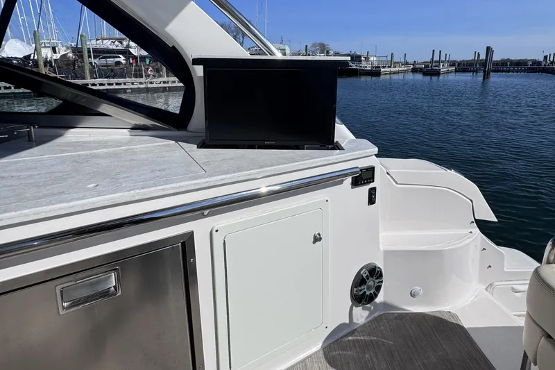 Slide: The Image of 2020 Regal 33 XO boat interior with TV, docked at marina. - 11