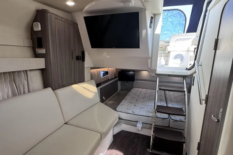 Slide: The Image of Interior of 2020 Regal 33 XO yacht featuring modern seating, TV, and ladder access. - 12