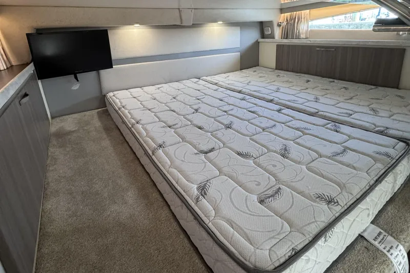 Slide: The Image of 2020 Regal 33 XO yacht interior cabin with twin mattresses and wall-mounted TV. - 17
