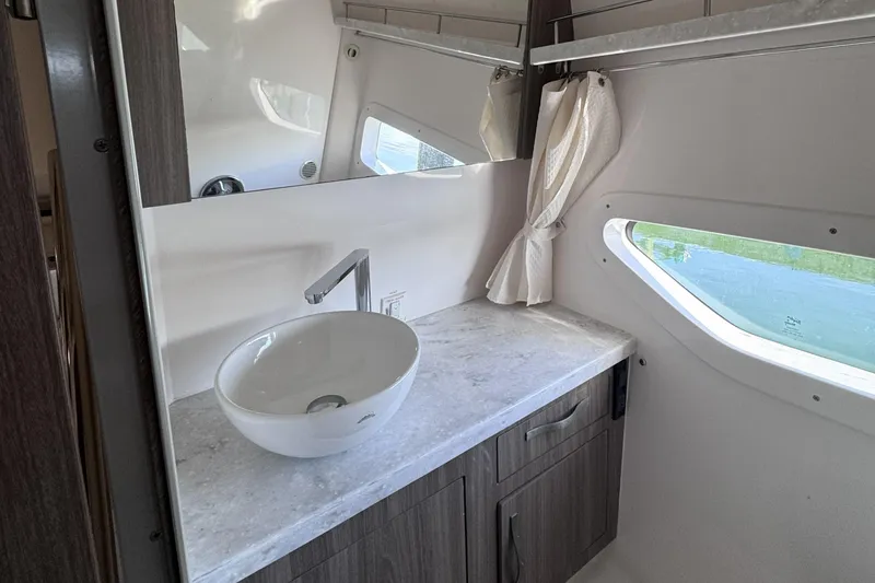 Slide: The Image of Modern bathroom interior of 2020 Regal 33 XO yacht with sleek sink and window. - 18