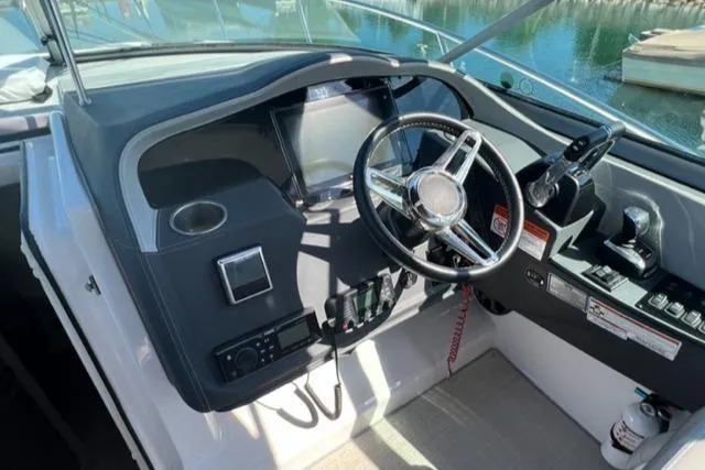 Slide: The Image of Cockpit of 2020 Regal 33 XO boat with steering wheel and control panel. - 2