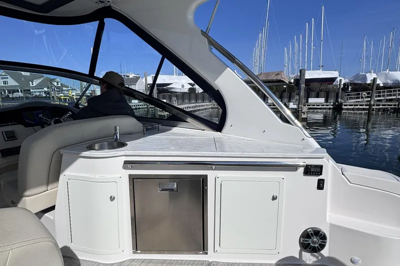 Slide: The Image of 2020 Regal 33 XO yacht interior with sleek design, docked at marina under clear blue sky. - 9