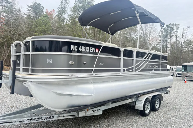 The Image of 2022 South Bay LE pontoon boat on trailer, parked outdoors. - 1