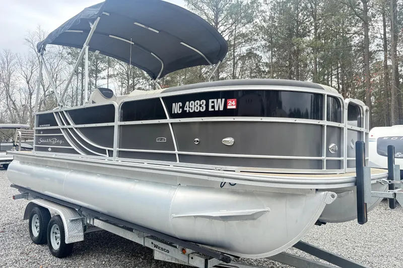 Slide: The Image of 2022 South Bay LE pontoon boat on trailer, parked outdoors with canopy. - 4