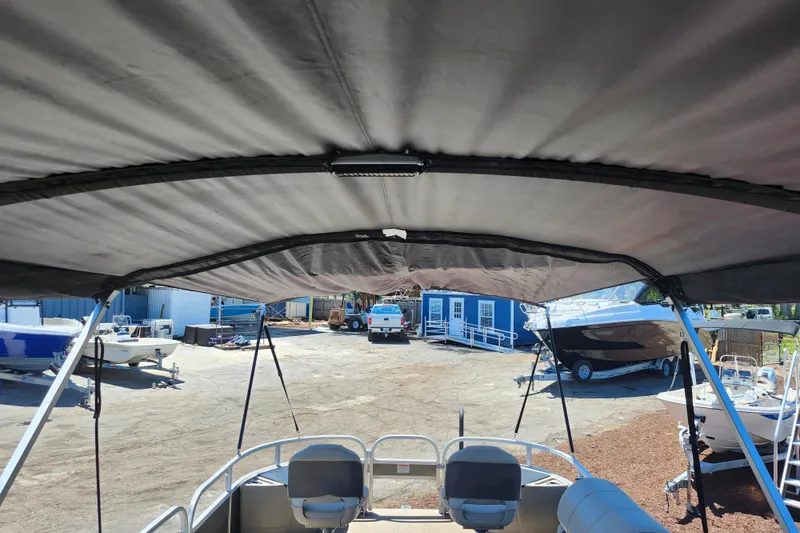 Slide: The Image of 2023 Sun Tracker Fishin' Barge 22 XP3 interior view with canopy and seating. - 14