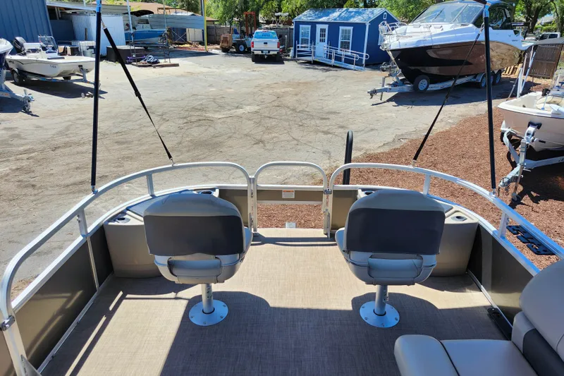Slide: The Image of 2023 Sun Tracker Fishin' Barge 22 XP3 interior with seating, docked at a marina. - 20