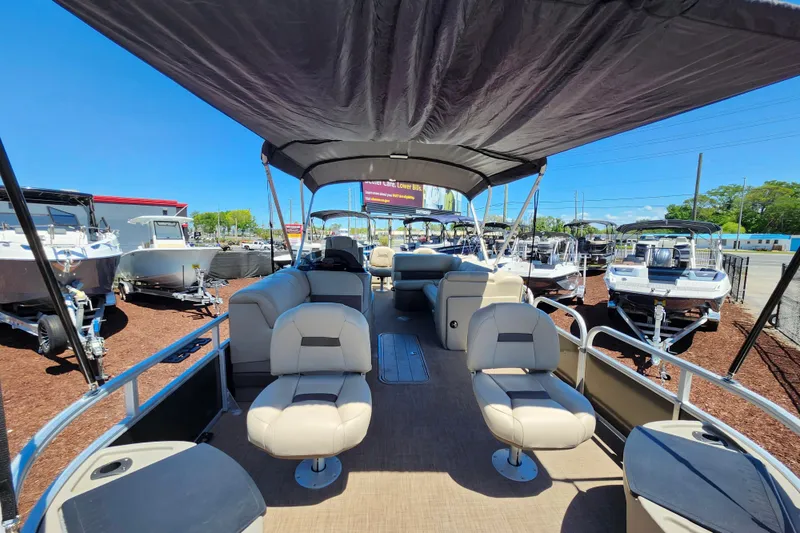 Slide: The Image of 2023 Sun Tracker Fishin' Barge 22 XP3 pontoon boat interior with seating and canopy. - 26
