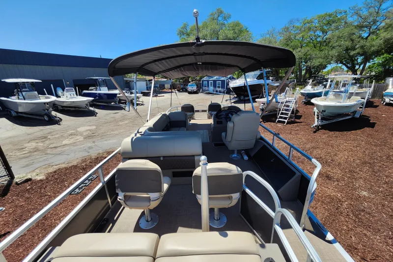 Slide: The Image of 2023 Sun Tracker Fishin' Barge 22 XP3 pontoon boat with canopy, docked outdoors. - 27