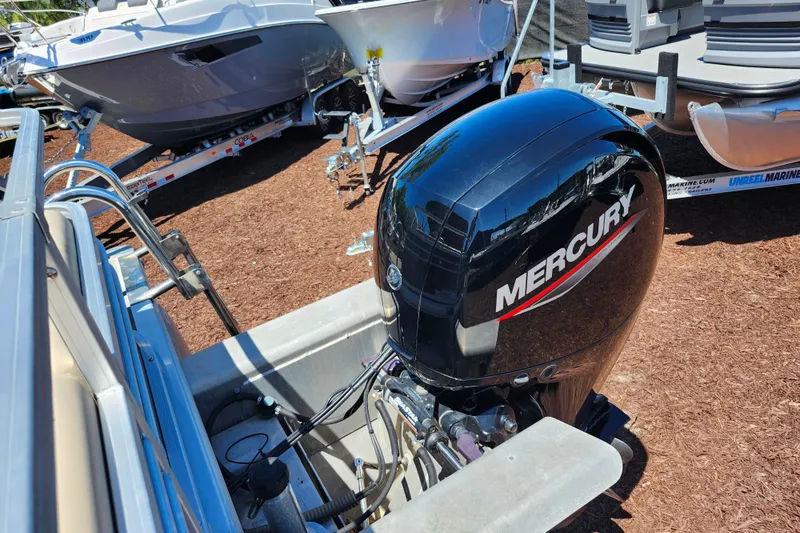 Slide: The Image of 2023 Sun Tracker Fishin' Barge 22 XP3 with Mercury outboard motor displayed outdoors. - 29