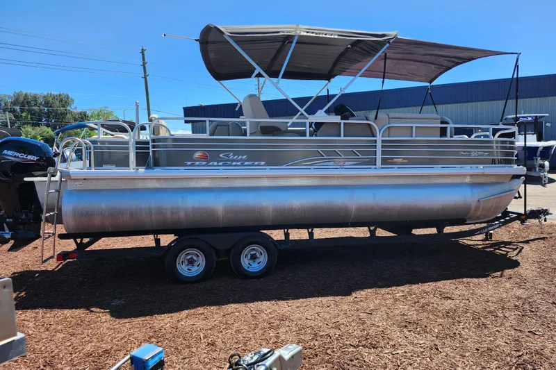 Slide: The Image of 2023 Sun Tracker Fishin' Barge 22 XP3 pontoon boat on trailer, parked outdoors. - 5