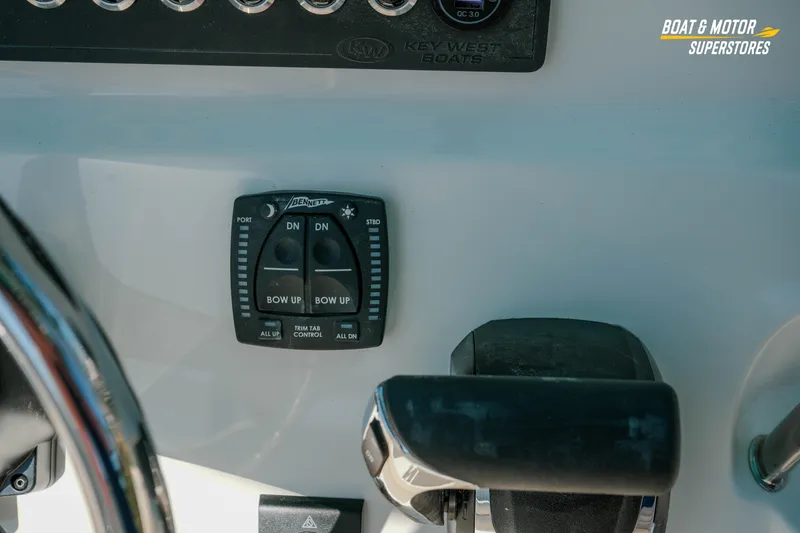 Slide: The Image of Control panel of 2026 Key West 239 FS boat with trim tab switches. - 14