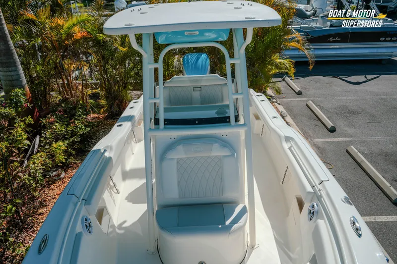Slide: The Image of 2026 Key West 239 FS boat interior with seating and console, parked outdoors. - 17