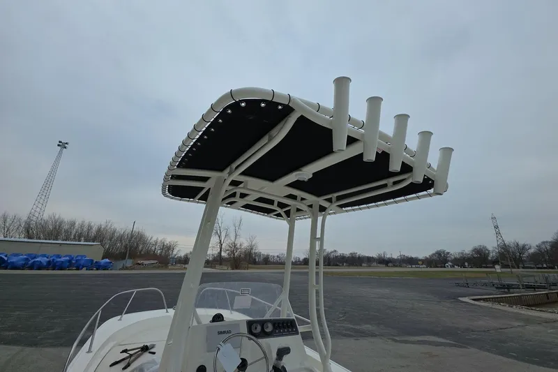 Slide: The Image of 2026 Boston Whaler 190 Montauk boat with T-top and rod holders, parked outdoors. - 11