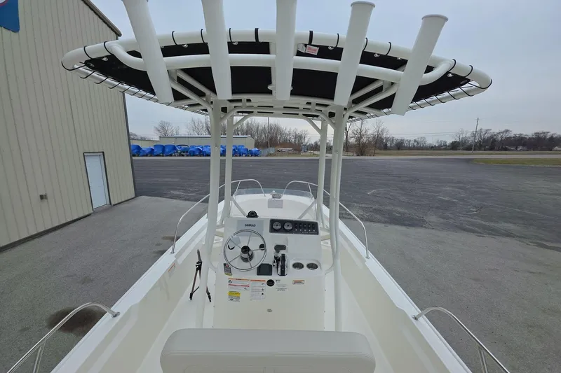 Slide: The Image of 2026 Boston Whaler 190 Montauk boat with T-top and steering console, parked outdoors. - 17