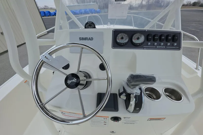 Slide: The Image of 2026 Boston Whaler 190 Montauk boat console with steering wheel and controls. - 7